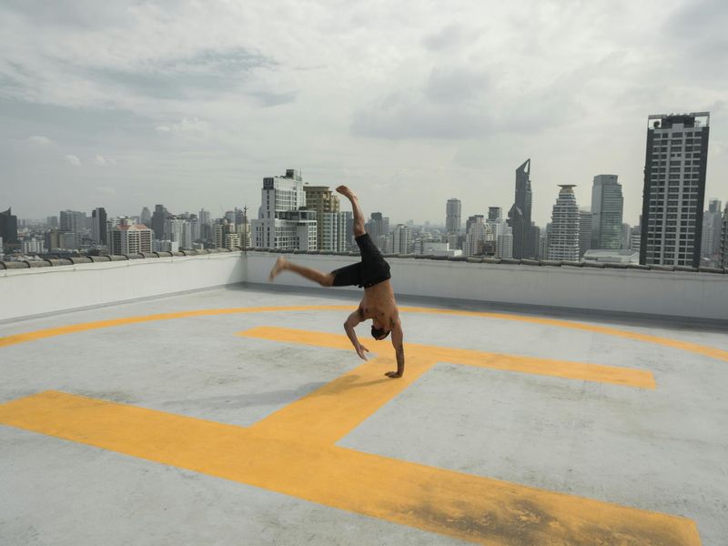 Man in mid-motion during a dynamic strength exercise, blurred background.