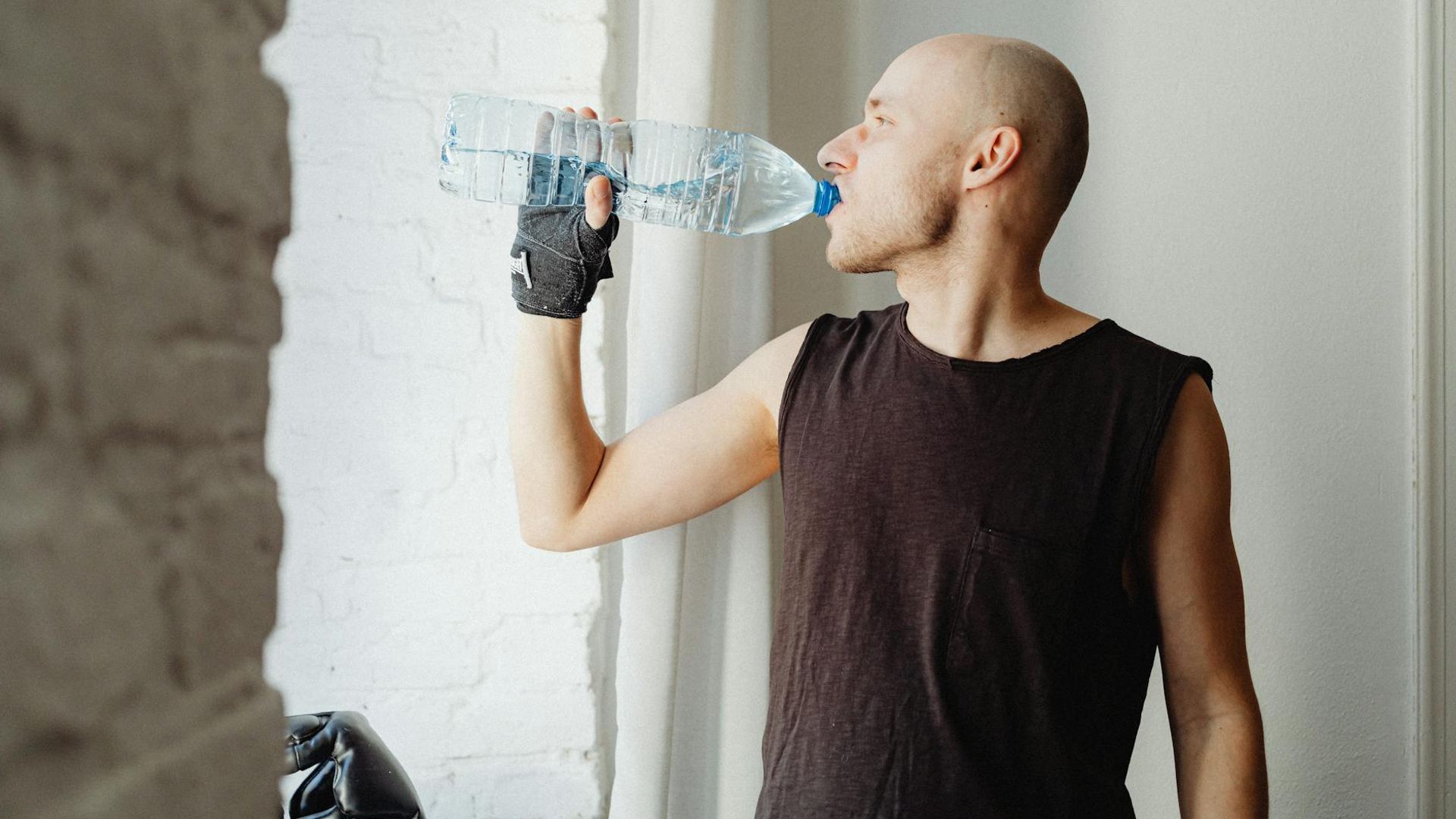Man performing a controlled bodyweight exercise in a minimalist gym setting.
